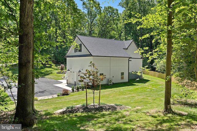 5570 Warren Dr, Huntingtown, MD 20639 - view of side of home with a yard, a shingled roof, and asphalt driveway