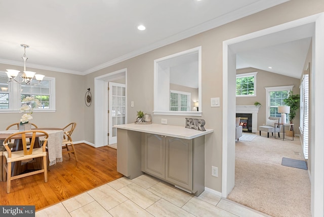 8002 Gosport Ln, Springfield, VA 22151 - kitchen featuring gray cabinets, light countertops, a glass covered fireplace, a chandelier, and baseboards