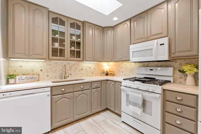 8002 Gosport Ln, Springfield, VA 22151 - kitchen with white appliances, a sink, a skylight, light countertops, and glass insert cabinets