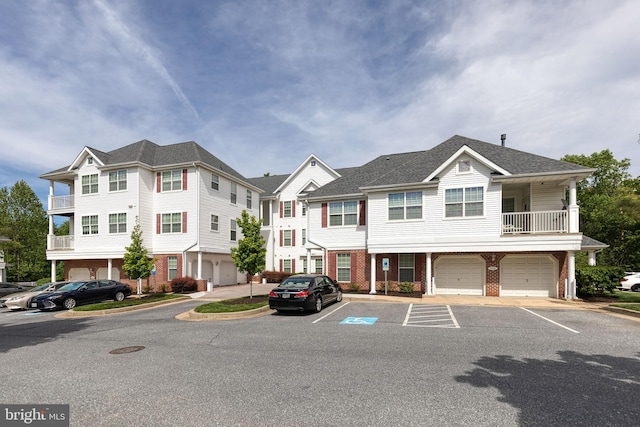 9663 Devedente Dr Unit 101, Owings Mills, MD 21117 - view of front of home with brick siding, a garage, and uncovered parking