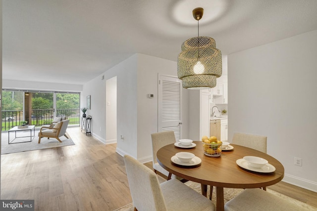 1300 Army Navy Dr Unit 124, Arlington, VA 22202 - dining area featuring baseboards and light wood finished floors