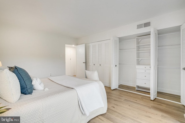 1300 Army Navy Dr Unit 124, Arlington, VA 22202 - bedroom featuring two closets, light wood-type flooring, and baseboards