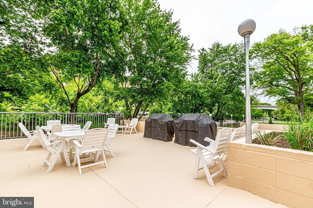 1300 Army Navy Dr Unit 124, Arlington, VA 22202 - view of patio / terrace featuring outdoor dining area, grilling area, and view of wooded area