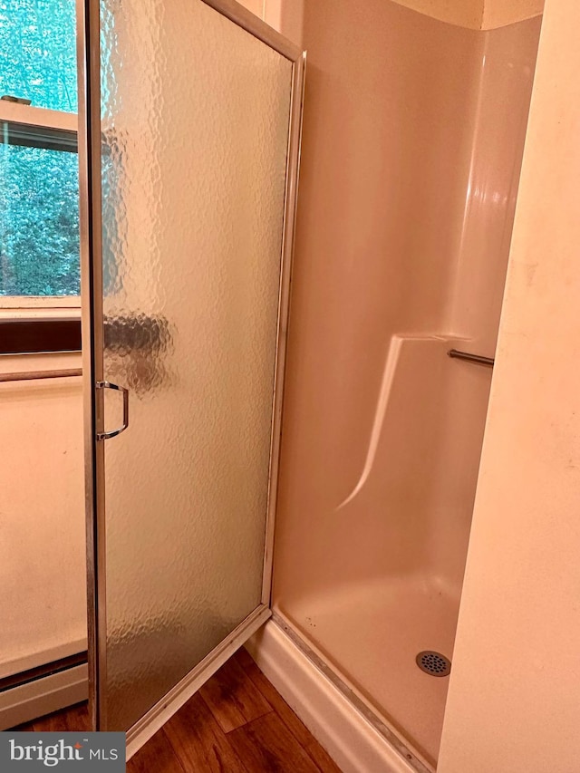 full bath with a shower stall and wood finished floors