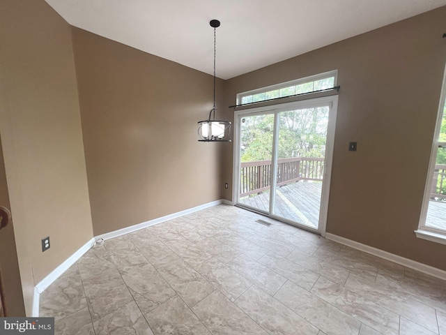 unfurnished dining area with plenty of natural light, baseboards, a chandelier, and lofted ceiling