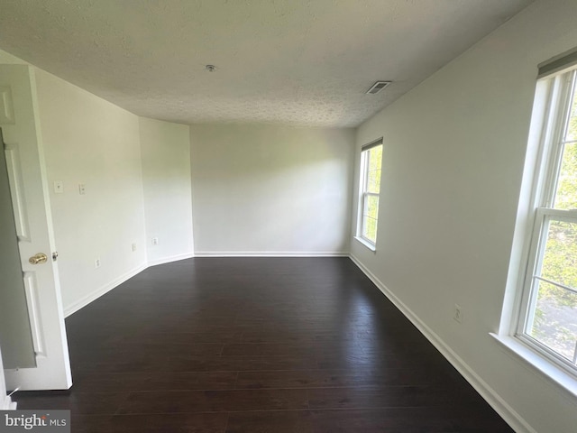 spare room with dark wood finished floors, baseboards, and a textured ceiling