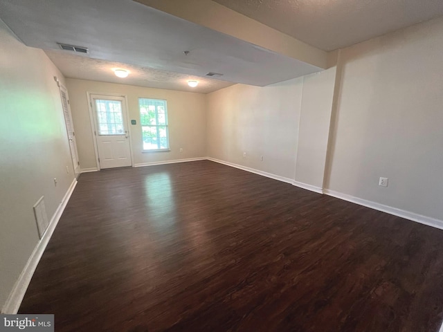 empty room featuring dark wood-style floors and baseboards