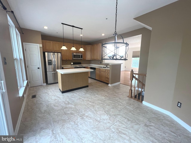 kitchen with stainless steel appliances, a sink, light countertops, a center island, and baseboards