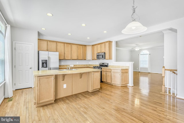 42952 Miltec Ter, Chantilly, VA 20152 - kitchen with appliances with stainless steel finishes, light brown cabinetry, light countertops, light wood-style floors, and a center island with sink