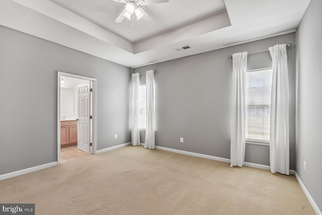 42952 Miltec Ter, Chantilly, VA 20152 - unfurnished bedroom featuring light carpet, a raised ceiling, baseboards, connected bathroom, and ceiling fan