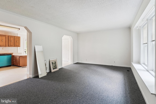 339 Gray Dr, Lusby, MD 20657 - unfurnished living room with arched walkways, a textured ceiling, and baseboards