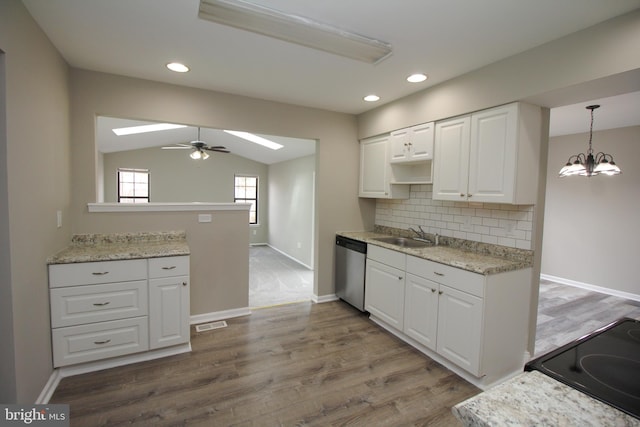 kitchen featuring stainless steel dishwasher, a skylight, black range with electric stovetop, white cabinetry, and backsplash