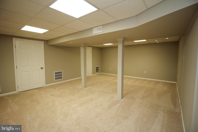 finished basement featuring a drop ceiling, light colored carpet, and baseboards