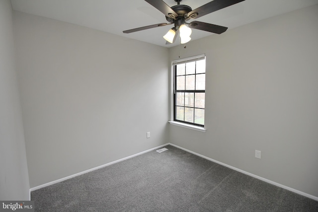 unfurnished room featuring baseboards, dark carpet, and a ceiling fan