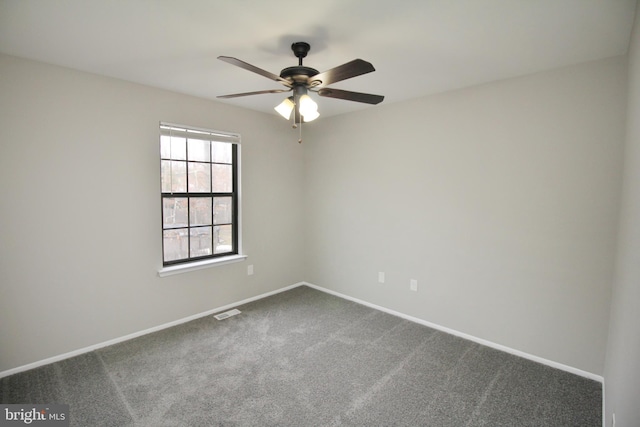empty room with a ceiling fan, dark carpet, and baseboards