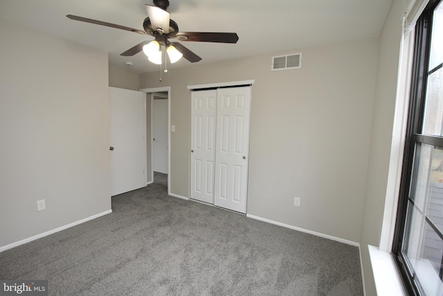 unfurnished bedroom with carpet, a closet, baseboards, and ceiling fan