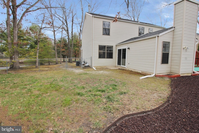 rear view of house featuring a chimney and a shingled roof