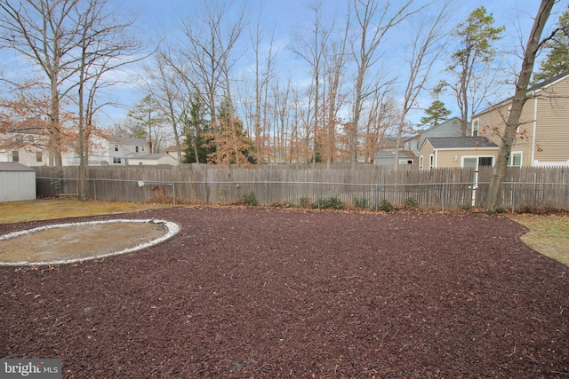 fenced backyard featuring a residential view, a storage shed, and an outbuilding