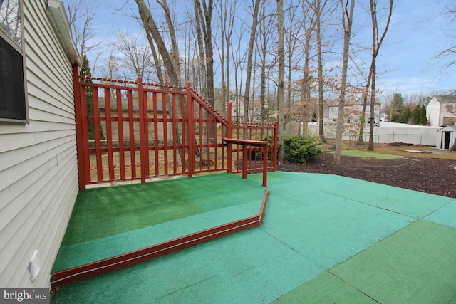 wooden terrace featuring a fenced backyard and a patio