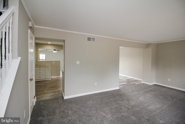 unfurnished room featuring crown molding, dark carpet, baseboards, and ceiling fan