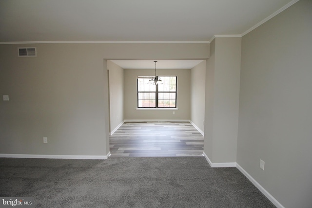 empty room featuring baseboards, a chandelier, ornamental molding, and carpet