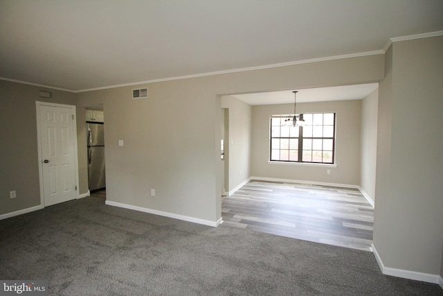 unfurnished room featuring baseboards, a chandelier, carpet flooring, and ornamental molding
