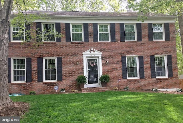 view of front of property with a front yard and brick siding