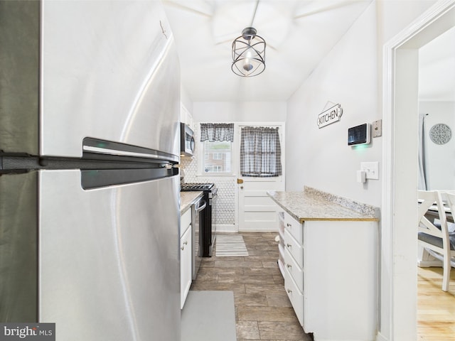 8663 Black Oak, Baltimore, MD 21234 - kitchen with stainless steel appliances, light countertops, white cabinets, and wood finished floors