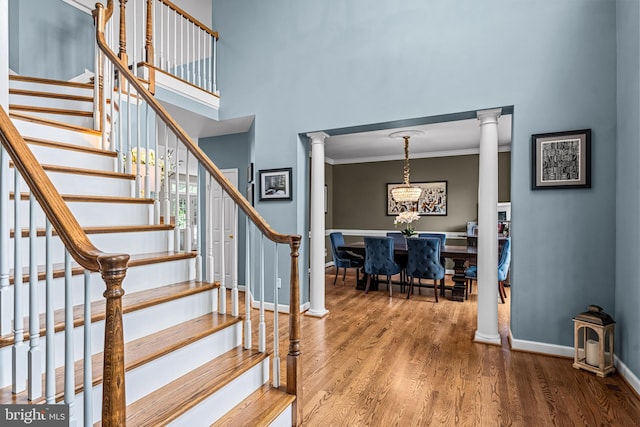 115 Hartefeld Dr, Avondale, PA 19311 - stairs with wood finished floors, decorative columns, a chandelier, ornamental molding, and baseboards