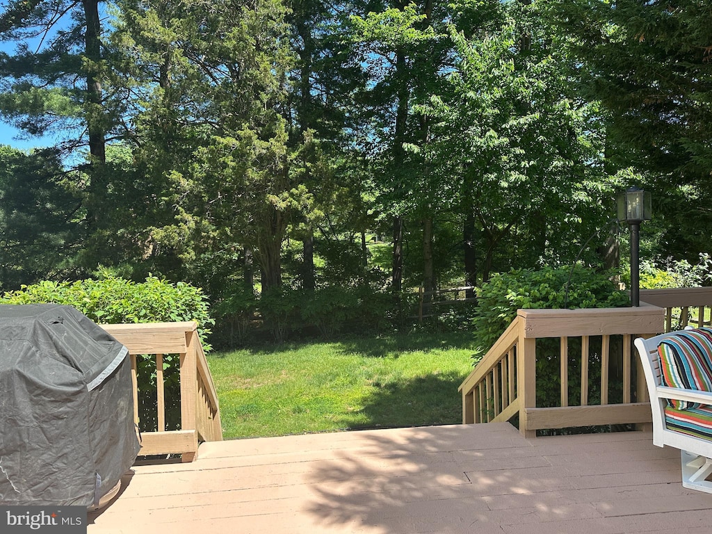 wooden deck with a yard and view of scattered trees