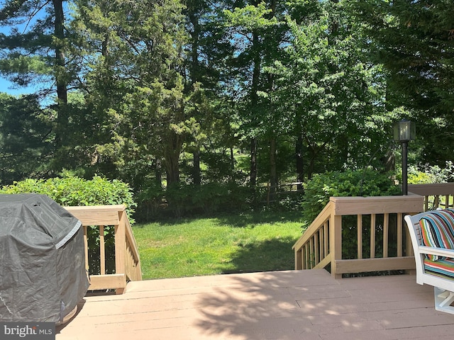 wooden deck with a yard and view of scattered trees