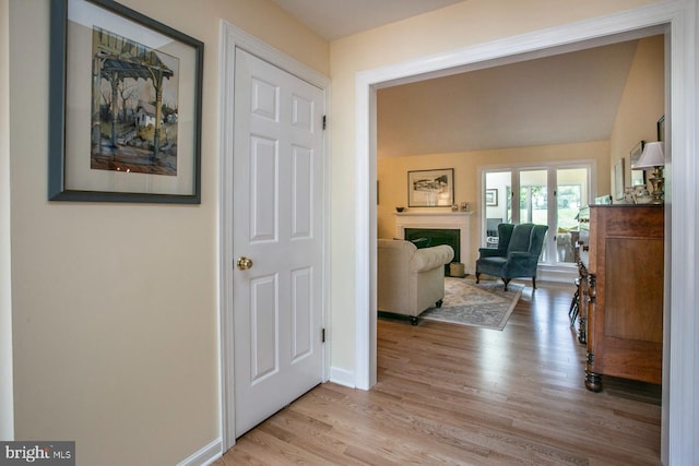 hall featuring light wood-type flooring and baseboards