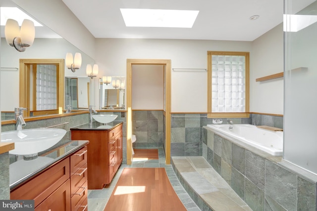 618 20th St S, Arlington, VA 22202 - full bathroom with tile walls, two vanities, a skylight, a whirlpool tub, and toilet