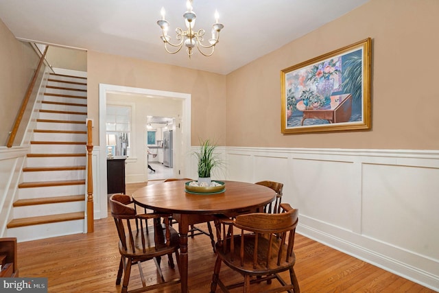 759 Avenue F, Langhorne, PA 19047 - dining space featuring light wood-type flooring, stairs, a chandelier, and a wainscoted wall