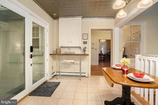 759 Avenue F, Langhorne, PA 19047 - kitchen featuring a baseboard heating unit, light tile patterned flooring, white cabinets, a chandelier, and an ornate ceiling