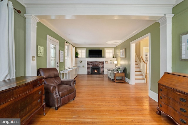 759 Avenue F, Langhorne, PA 19047 - living room featuring ornate columns, light wood finished floors, a brick fireplace, crown molding, and stairway