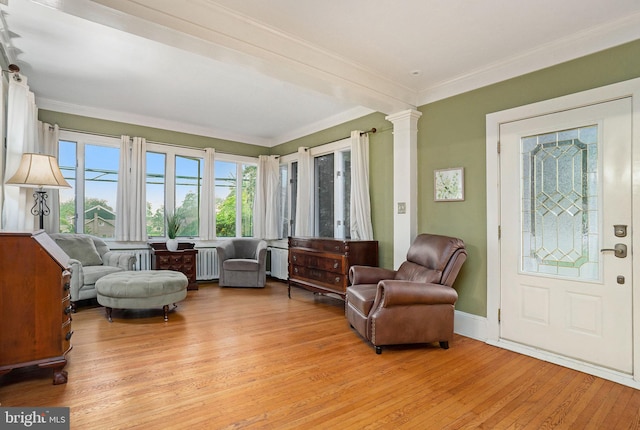 759 Avenue F, Langhorne, PA 19047 - living area featuring radiator heating unit, light wood finished floors, decorative columns, crown molding, and baseboards