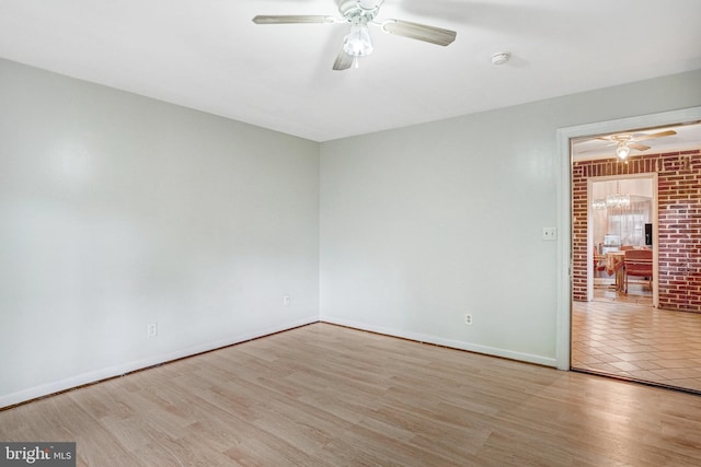 102 S Glebe Rd S, Arlington, VA 22204 - spare room featuring ceiling fan, baseboards, wood finished floors, a smoke detector, and brick wall