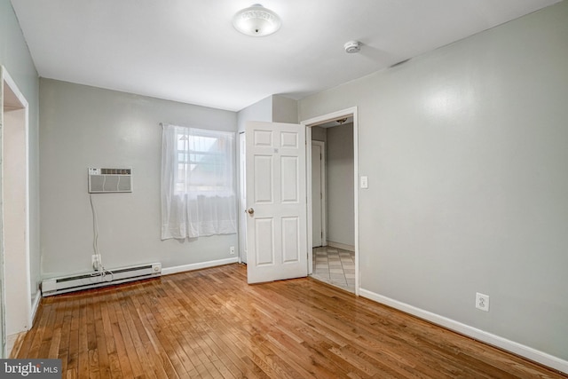 102 S Glebe Rd S, Arlington, VA 22204 - unfurnished bedroom featuring a baseboard heating unit, light wood-style floors, baseboards, and an AC wall unit