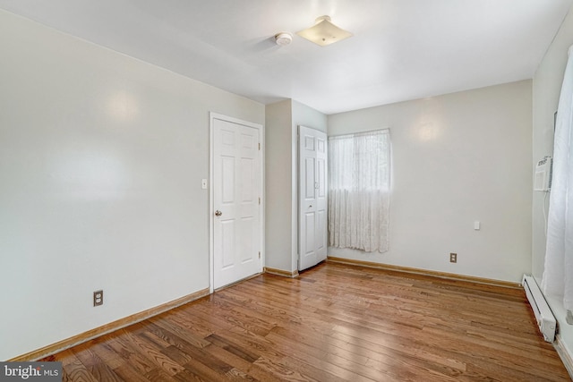 102 S Glebe Rd S, Arlington, VA 22204 - unfurnished bedroom with baseboard heating, wood finished floors, and baseboards