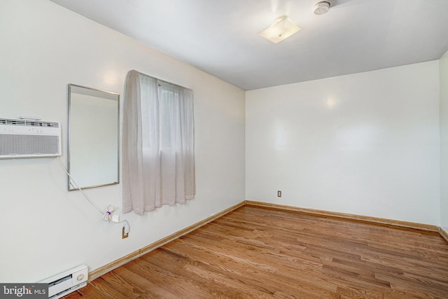 102 S Glebe Rd S, Arlington, VA 22204 - spare room featuring a baseboard radiator, wood finished floors, a smoke detector, baseboards, and a wall unit AC