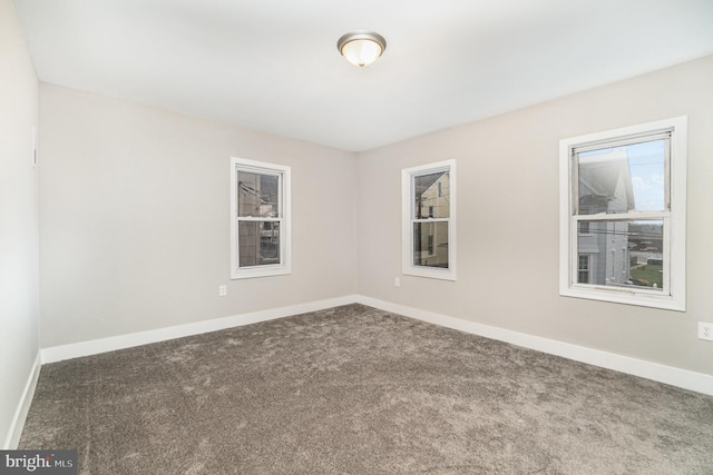 spare room featuring carpet flooring and baseboards