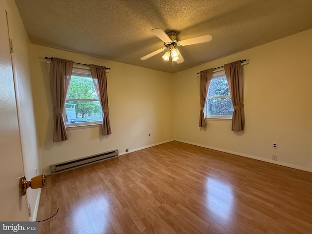 64 Mulberry St, Franklin, WV 26807 - unfurnished room featuring baseboard heating, healthy amount of natural light, a textured ceiling, wood finished floors, and a ceiling fan