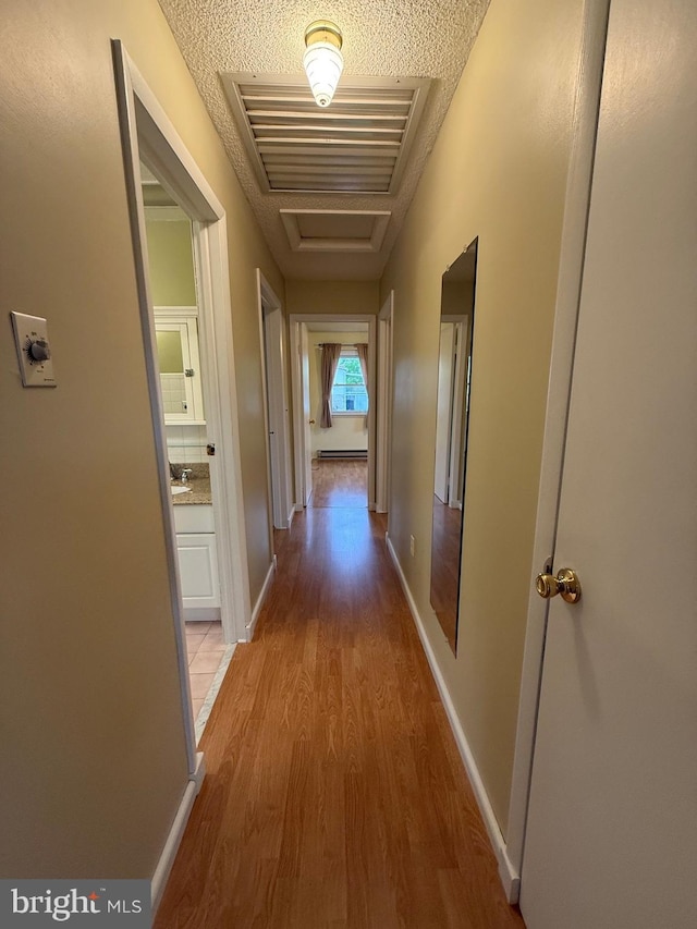 64 Mulberry St, Franklin, WV 26807 - corridor with light wood finished floors, baseboards, and a textured ceiling