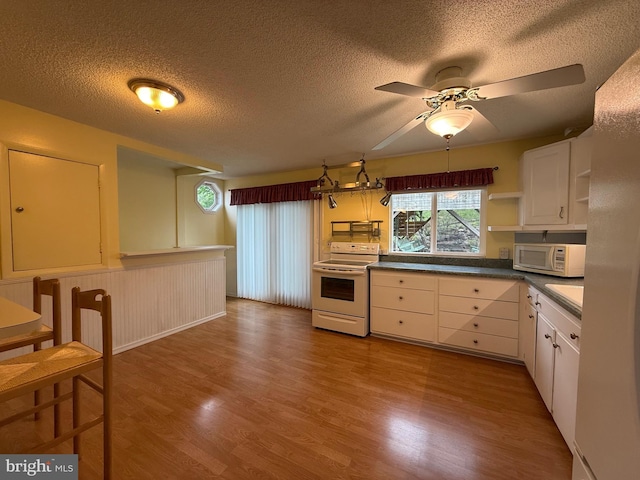 64 Mulberry St, Franklin, WV 26807 - kitchen featuring white appliances, a textured ceiling, open shelves, wood finished floors, and ceiling fan