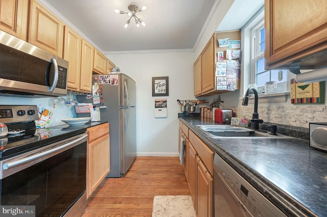 59 Wyatt St, Frederica, DE 19946 - kitchen featuring appliances with stainless steel finishes, dark countertops, a sink, light wood finished floors, and crown molding