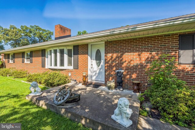 931 Oakdale Cir, Millersville, MD 21108 - view of front of house with a chimney, brick siding, a front lawn, and a patio area