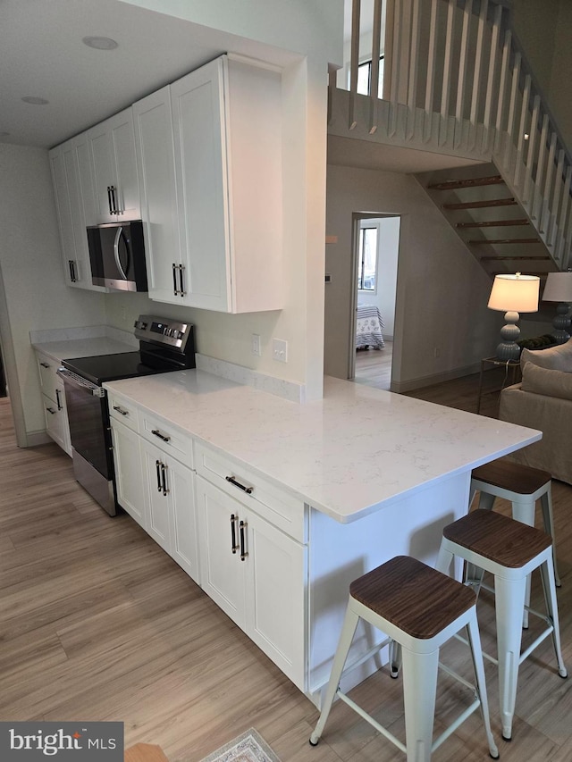 6 Granby Ln, Ocean Pines, MD 21811 - kitchen featuring stainless steel appliances, light wood finished floors, open floor plan, and white cabinets