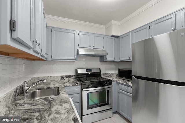 kitchen featuring stainless steel appliances, under cabinet range hood, gray cabinetry, crown molding, and a sink