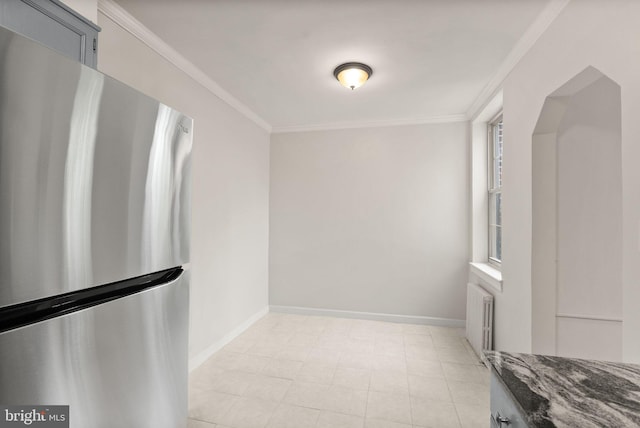 unfurnished dining area featuring radiator, ornamental molding, and baseboards